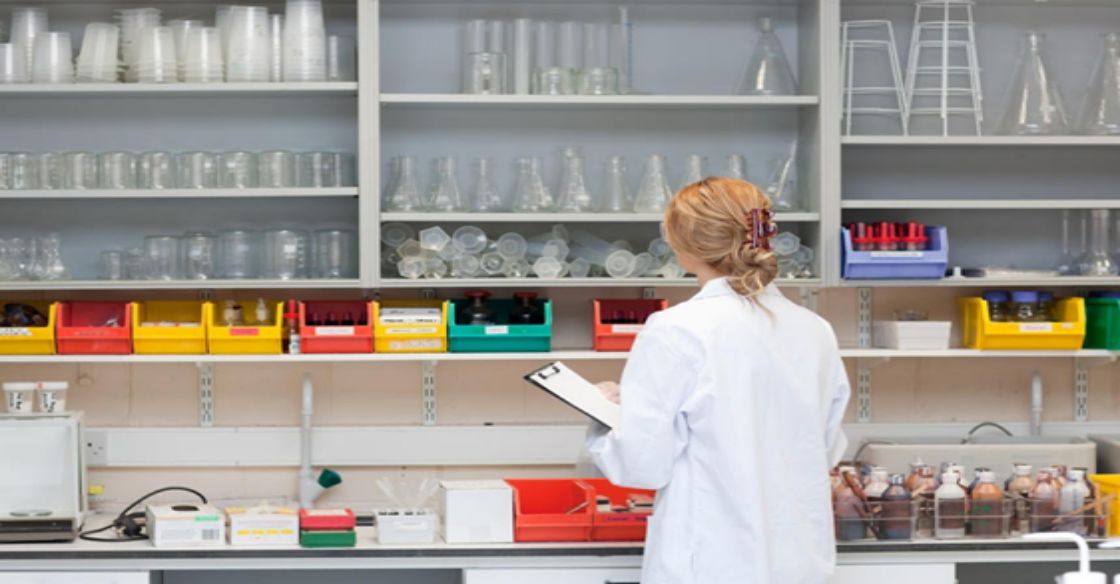 Female scientist inspecting lab equipment